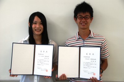 賞状を掲げる大学院自然科学研究科修士課程2年の永井 翼さん（写真右）と理学部4年の平井 柔さん（写真左）