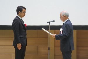 表彰状を受け取る佐藤努准教授