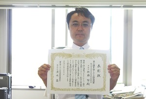 表彰状を手にする佐藤努准教授