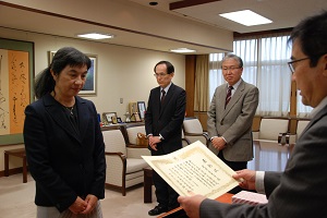 髙橋学長(右)から賞状を手渡される定方教授(左)