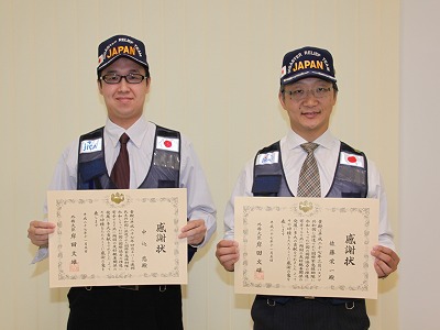 賞状を掲げる医学部災害医療教育センターの佐藤 栄一特任准教授(写真右)と医学部災害医療教育センター中込 悠特任助教(写真左)