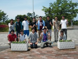 環境系サークル「ひまわり」の学生と職員による正門周辺プランターの花の植替えの様子