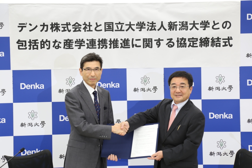 握手を交わすデンカ株式会社の吉髙代表取締役社長(左)と髙橋学長(右)
