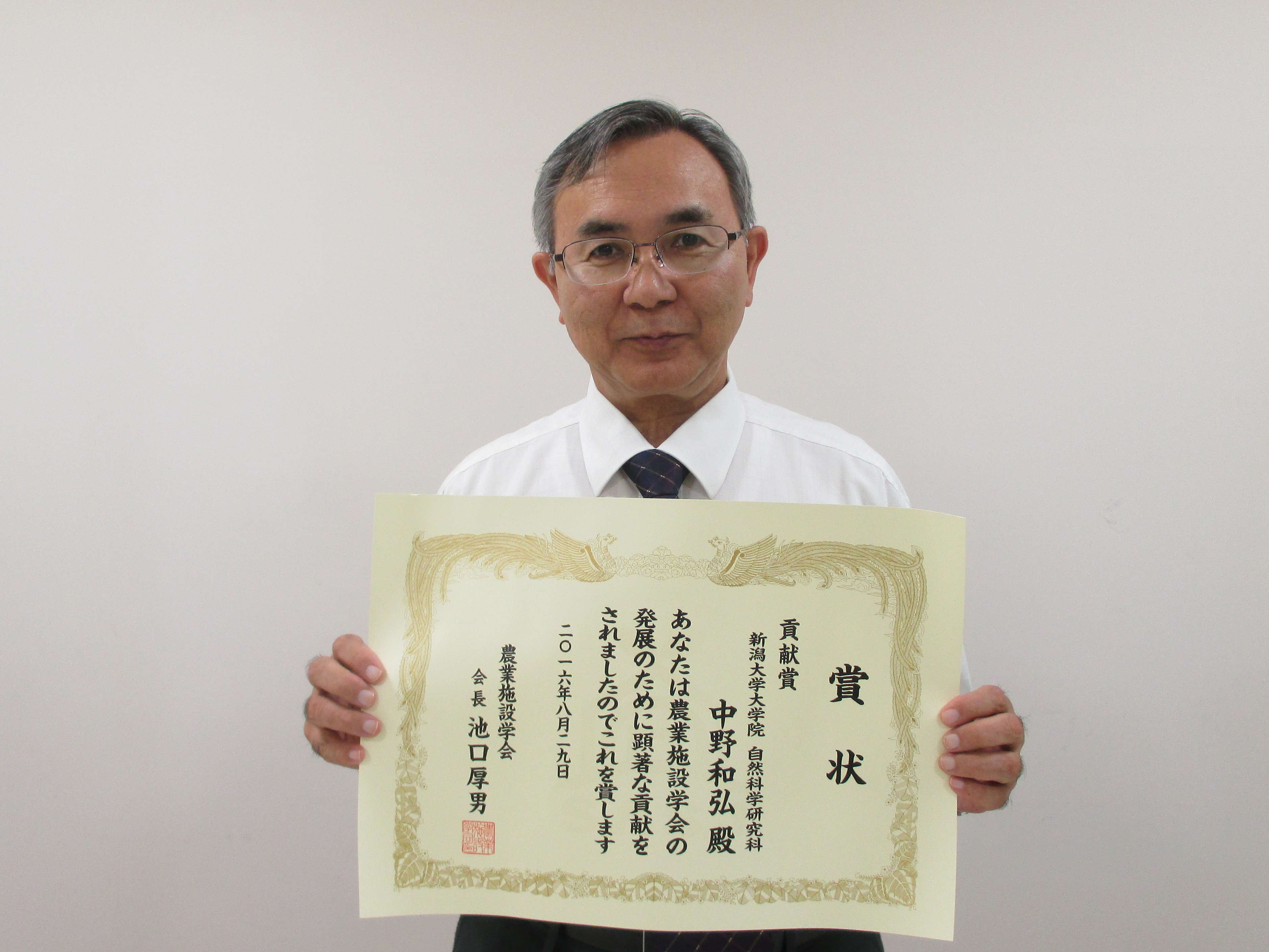 賞状を掲げる中野和弘教授（大学院自然科学研究科（農学部兼任））