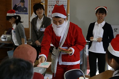 サンタクロースに扮した学生がひとりずつにクリスマスカードを手渡しました
