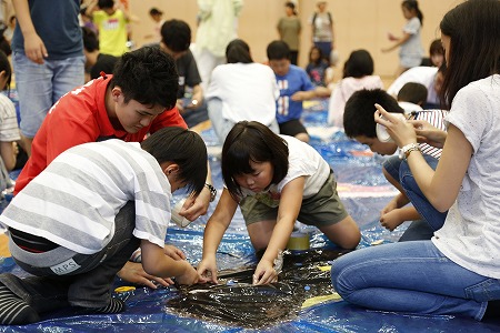 一生懸命制作する学生と子ども達