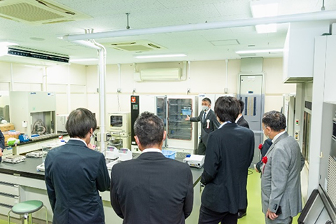 ラボツアーの案内をする平田副センター長（写真奥）