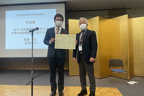 賞状を掲げる災害・復興科学研究所の新屋啓文准教授（写真左）