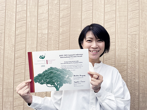 賞状を掲げる若林悦子助教(工学部/協創経営プログラム)