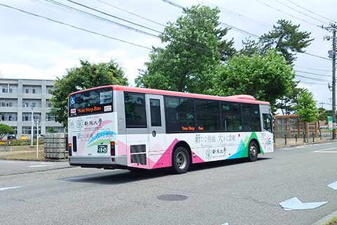 新潟大学旧正門付近を走行するラッピングバスの写真