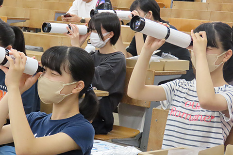 天体望遠鏡を覗く受講生の写真